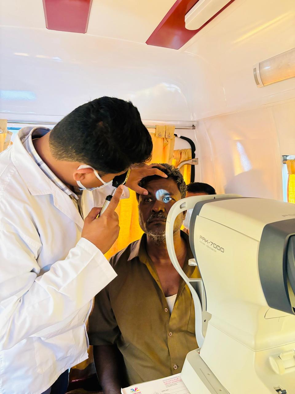 Doctor examining a patient's eye at a mobile eye care van